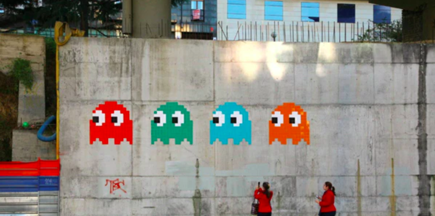 Street art door Invader met zijn typische Pac-Man stijl