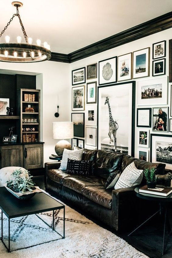 Eclectic interior including framed personal photos and various materials such as a vintage leather sofa and a wool rug